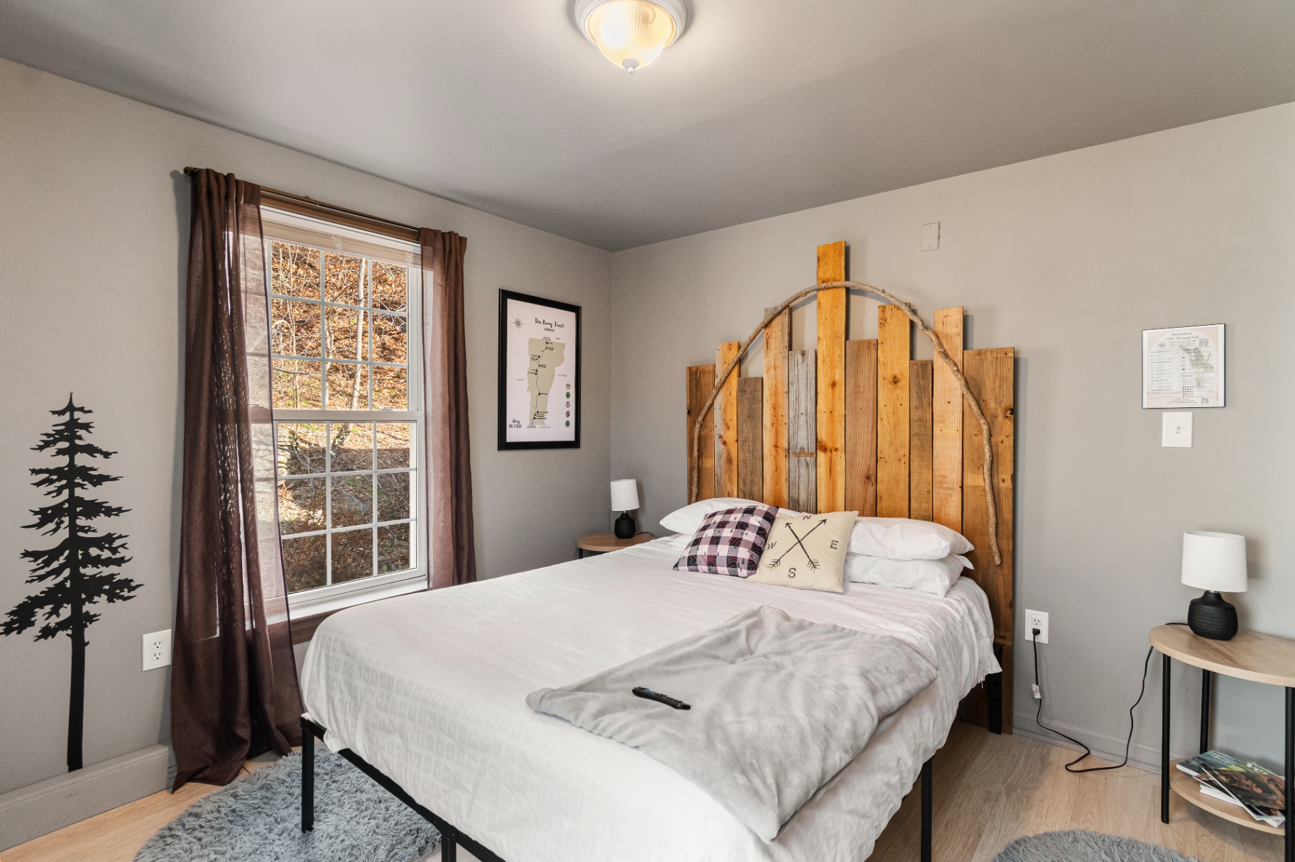 Queen bed with rustic wood headboard in the Long Trail Suite