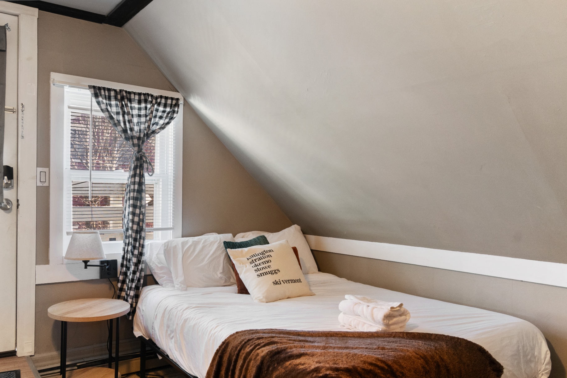 Bed with Ski Vermont pillow by the window