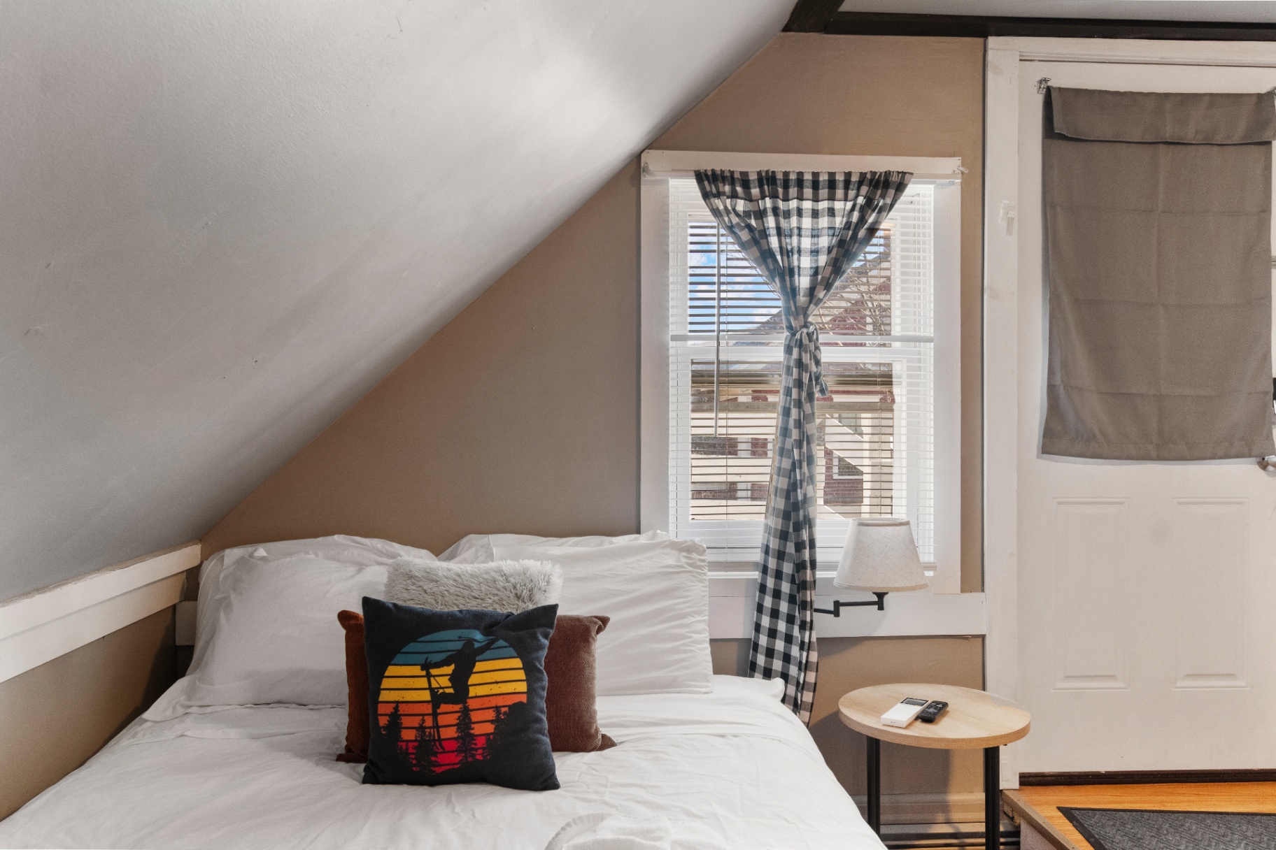 Bed with ski-themed throw pillow and window